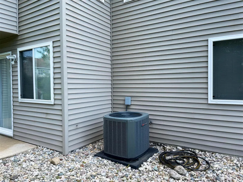 Before: grey siding and corner of a Zeeland home with green algae streaks